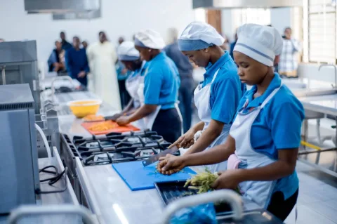 Hospitality trainees preparing food in a training kitchen